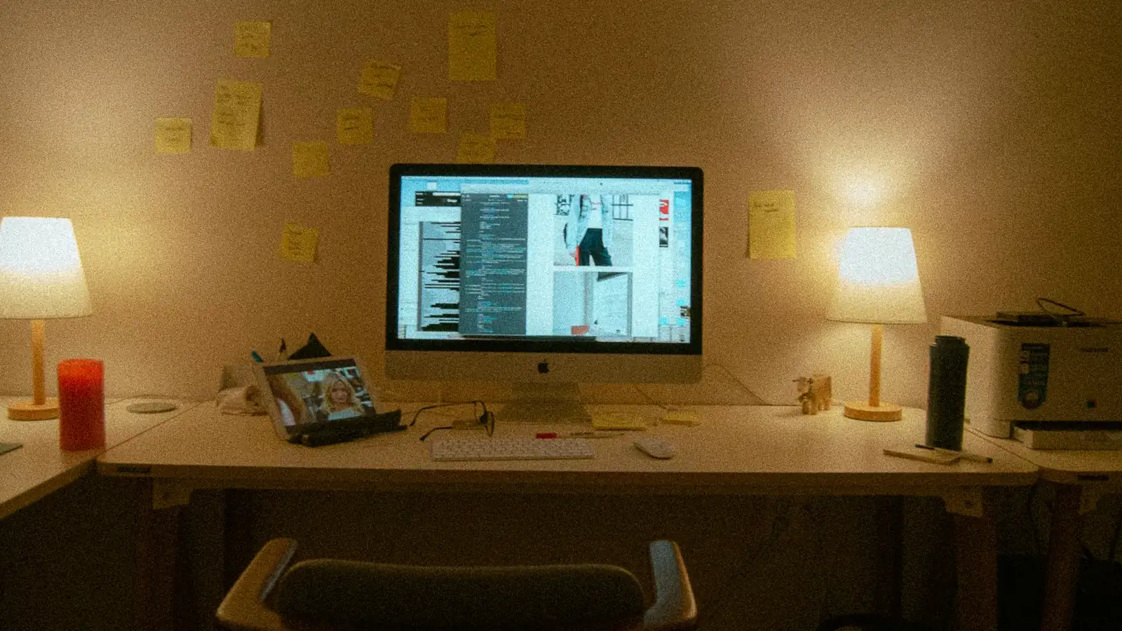 Workspace with monitor, desk lamps and sticky notes for content planning